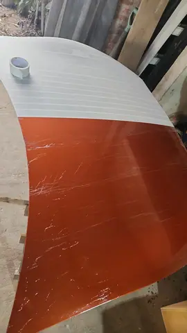 El capó original naranja cubierto a medias con una capa blanca de cera desmoldante.