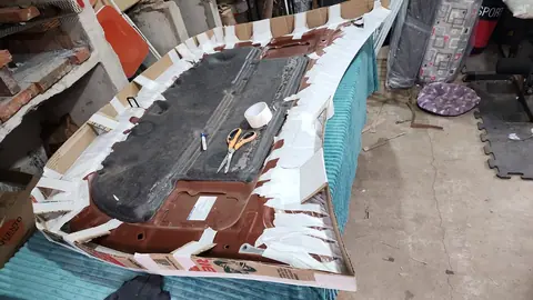 El capó dado vuelta con un borde de cartón y tiras de cinta de papel alrededor de todo el perímetro.
