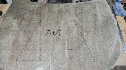 La pieza de fibra con el diseño trazado a lápiz y los kanjis ocho, diez y seis dibujados en el centro.