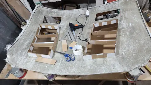 Estructuras de cartón corrugado numeradas a mano sobre la mesa de trabajo.