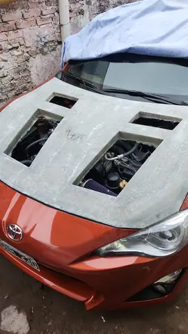 Vista cenital del capó crudo con las seis aberturas y el motor debajo.