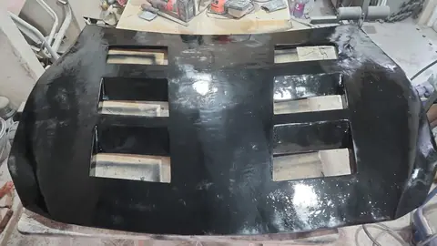 El capó terminado y pintado de negro brillante, con las seis tomas de aire.
